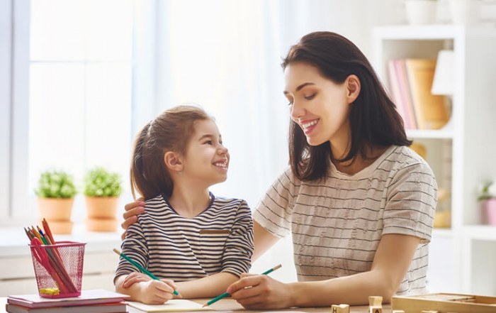 Mother helping her daughter with mathematics