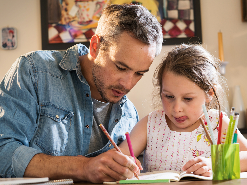 father helps daughter with her homework